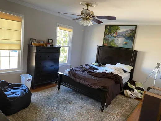 Bedroom with dark furniture dusted and bed made