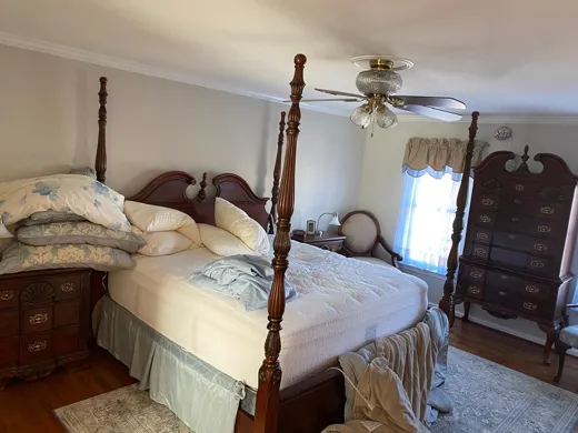 Bedroom with four-poster bed made up neatly
