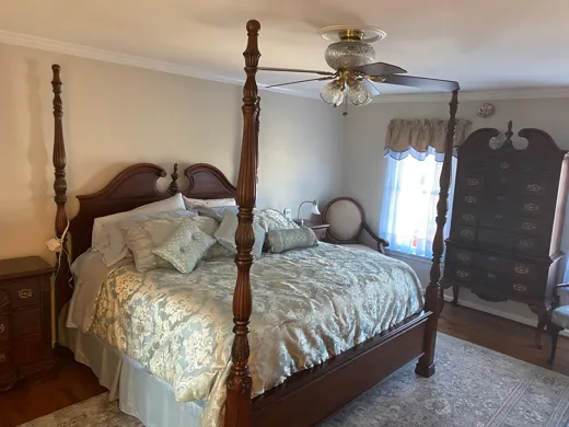 Bedroom with quilted bedding smoothed and dusted