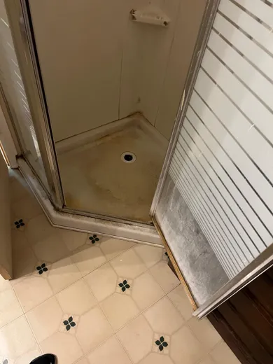 Corner shower stall cleaned with glass and tile bright