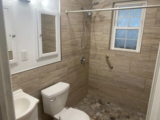Bathroom with toilet and tiled shower cleaned