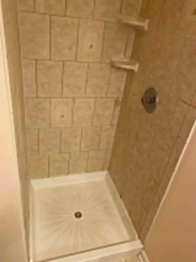 Tiled shower stall with pan scrubbed bright