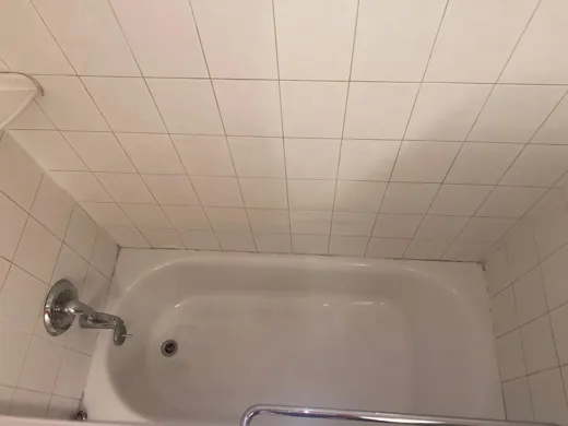 Tub and ceiling tile cleaned in older bathroom